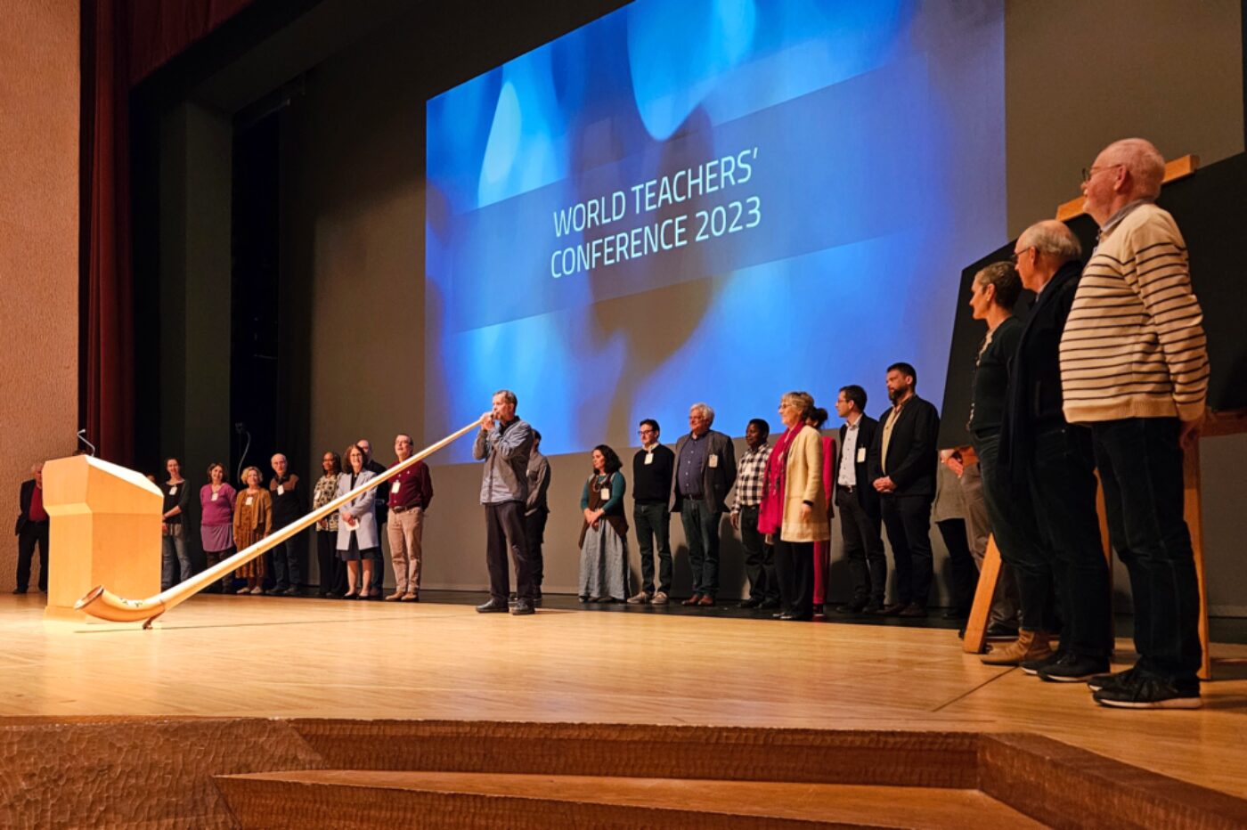 Benno Otter's alphorn sounds herald the 11th World Teachers' Conference. Behind him are the members of the Hague Circle and the Pedagogical Section, the organisers of the conference.